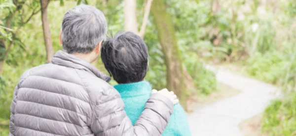 Happy couple walking in forest after regaining Erectile Dysfunction