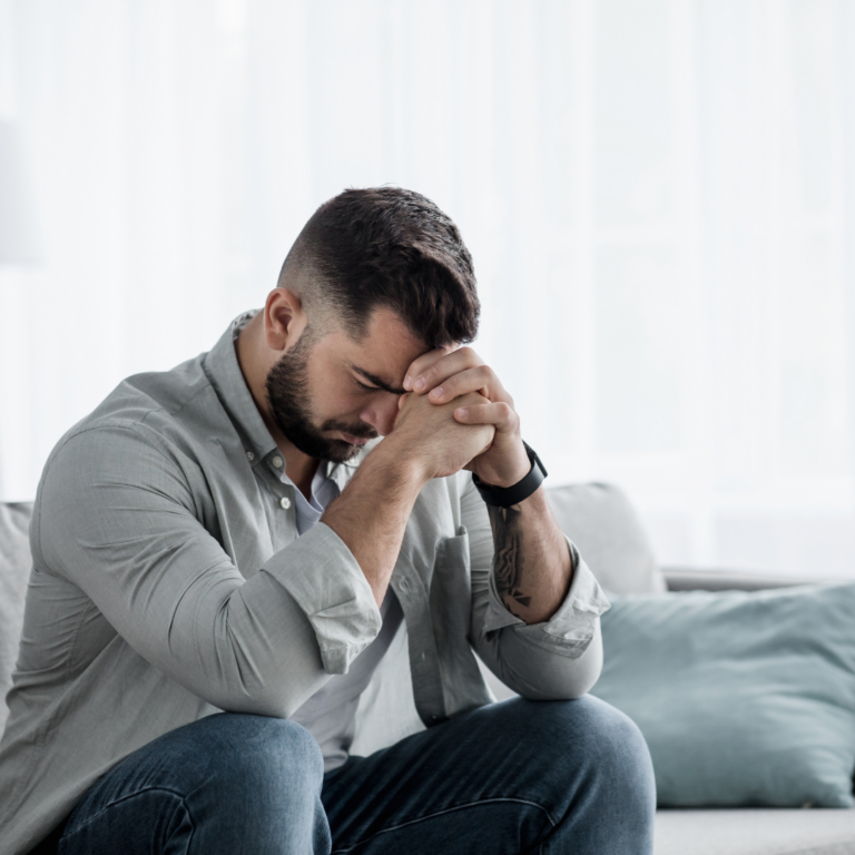 Anxious young man with hands on forehead
