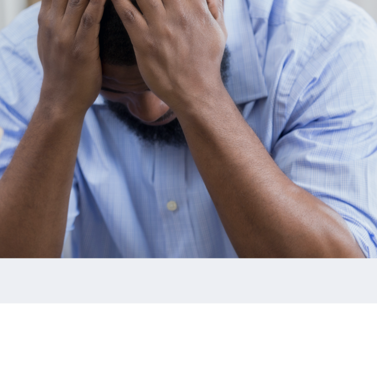 Man having his hands on his head and looking depressed.